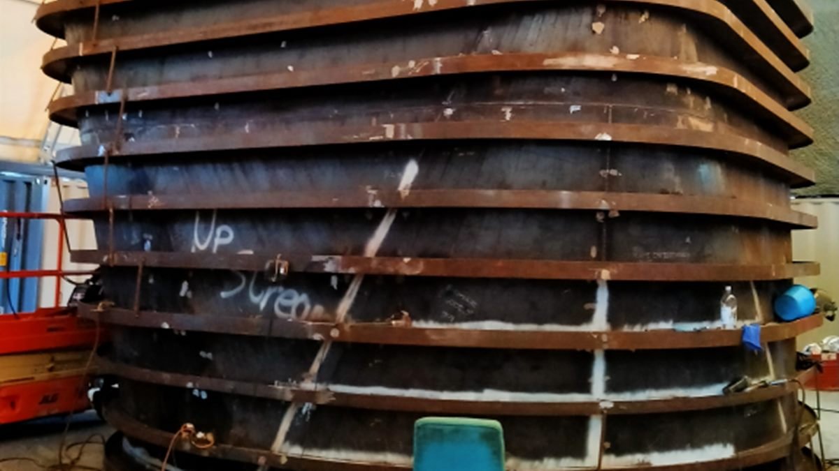 Large fabricated steel ring frames stacked in a workshop