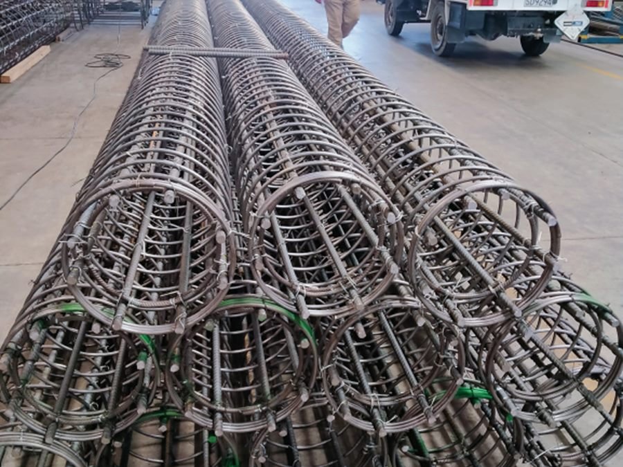 Rows of fabricated steel reinforcing cages laid out in a yard
