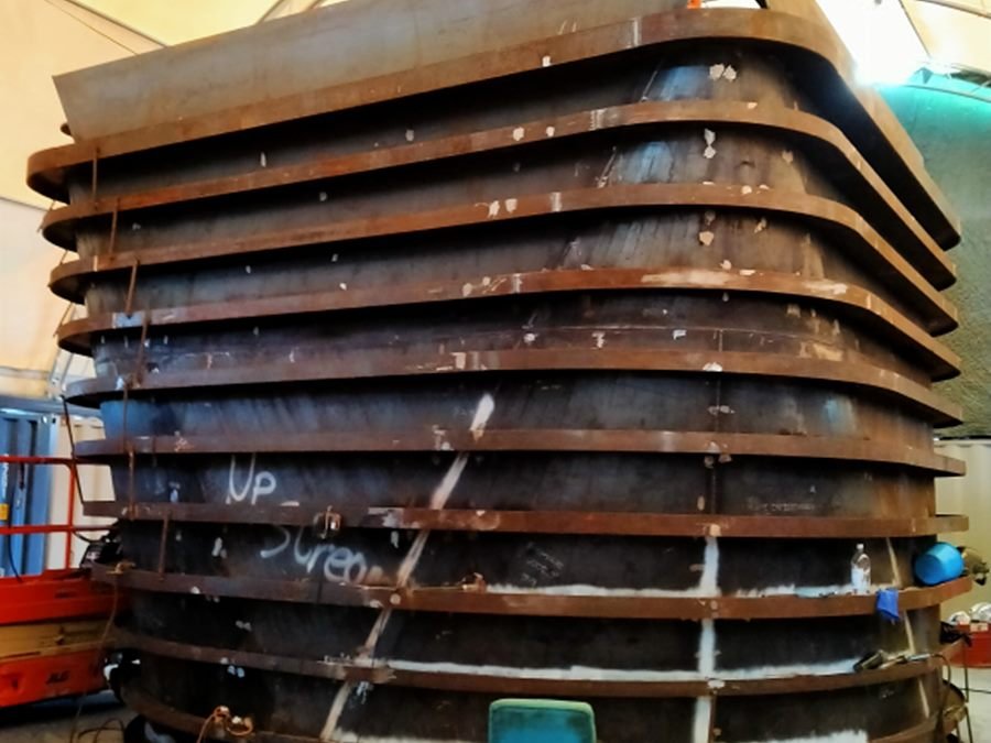 Large fabricated steel ring frames stacked in a workshop