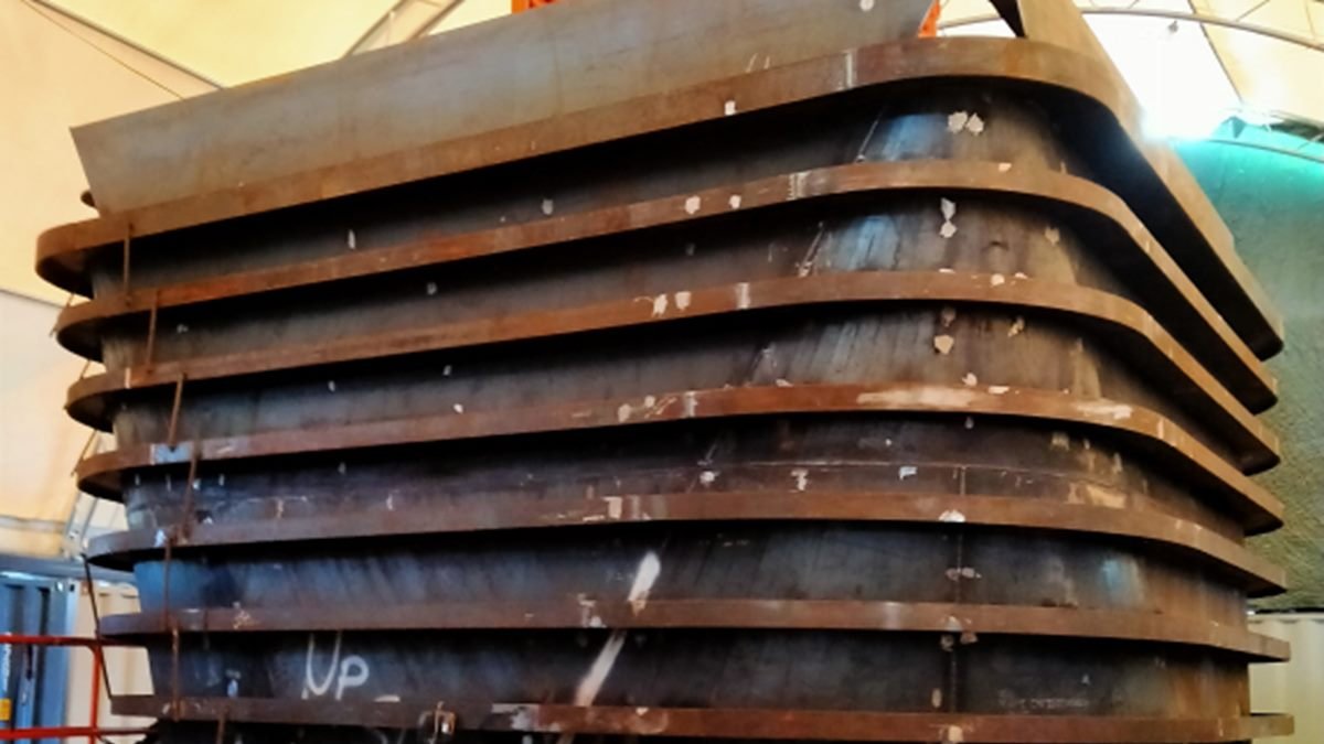 Large fabricated steel ring frames stacked in a workshop